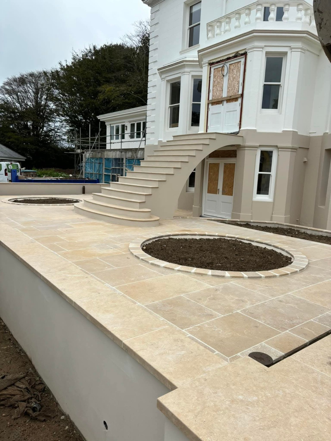 Stone-paved terrace and sweeping exterior staircase at a Rod Construction project